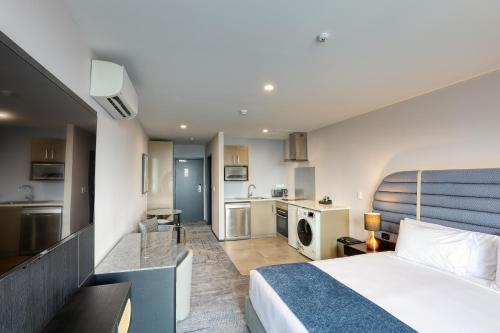 a hotel room with a bed and a kitchen at Marsden Suites Albany in Albany