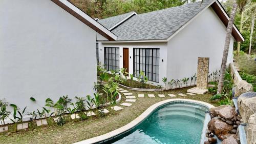 a house with a swimming pool in front of it at Malasama Suites Hotel in Kuta Lombok