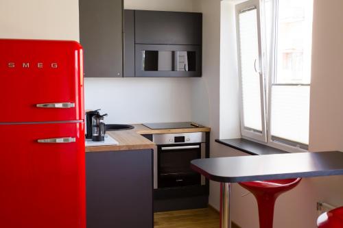 a kitchen with a red refrigerator and a table at Uus Street 34 Apartment in Kuressaare