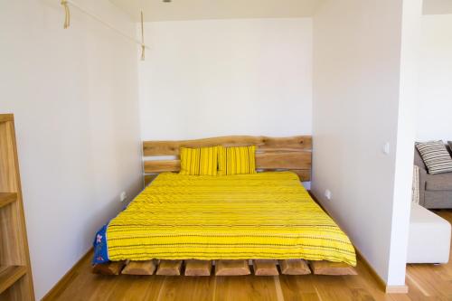 a bed in a room with a yellow blanket at Uus Street 34 Apartment in Kuressaare