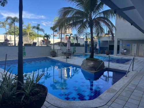 a swimming pool with palm trees in a resort at Serra Park in Rio Quente