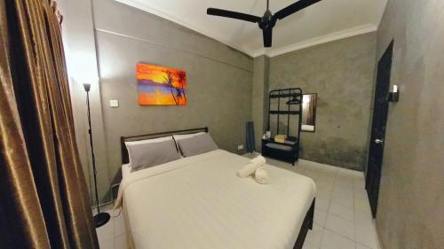 a bedroom with a white bed and a painting on the wall at 2-9pax GFloor PRIVATE BEACH, WATERSPORT, POOL, FREE BBQ Set, Wifi, 50"TV in Port Dickson