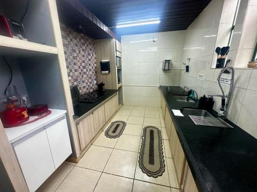 a kitchen with a sink and a drain in the floor at Quarto privado no Centro in Botucatu