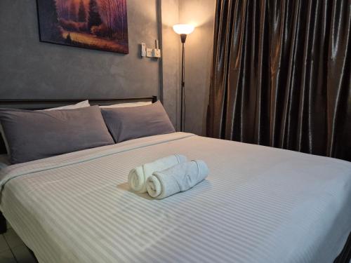 a bed with two rolls of towels on it at 2-9pax GFloor PRIVATE BEACH, WATERSPORT, POOL, FREE BBQ Set, Wifi, 50"TV in Port Dickson