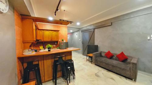 a kitchen with a bar and a couch in a room at 2-9pax GFloor PRIVATE BEACH, WATERSPORT, POOL, FREE BBQ Set, Wifi, 50"TV in Port Dickson