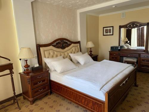 a bedroom with a bed and a dresser and a mirror at Hotel YOSHLIK in Navoi