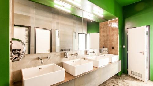 a bathroom with three sinks and a row of mirrors at Czech Inn in Prague