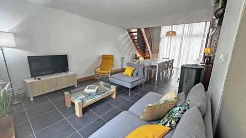 a living room with a couch and a tv at Le vieux tilleul in Bessines-sur-Gartempe