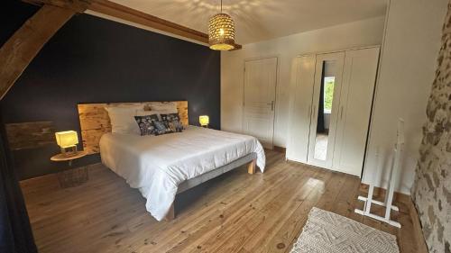 a bedroom with a large white bed in a room at Le vieux tilleul in Bessines-sur-Gartempe