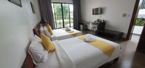a hotel room with two beds and a desk at Siem Reap Tevi Residence in Siem Reap