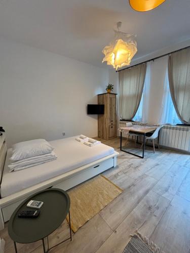 a bedroom with a bed and a table and chairs at Next Door Studio in Cluj-Napoca