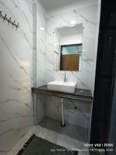 a bathroom with a sink and a mirror at Sadhana Agro Tourism in Ellora
