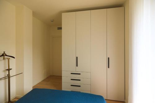 a bedroom with white cabinets and a blue bed at Villetta Isabella in Menaggio