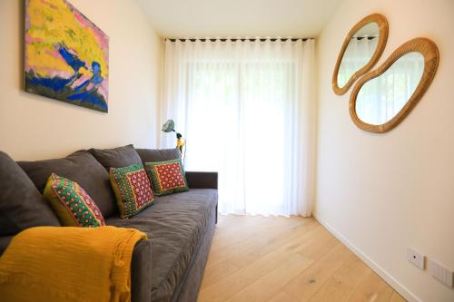 a living room with a couch and a large window at Villetta Isabella in Menaggio