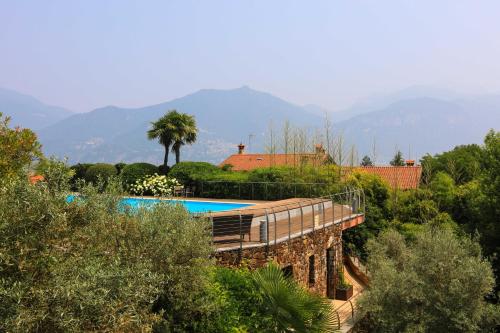 a house with a swimming pool with mountains in the background at Villetta Isabella in Menaggio