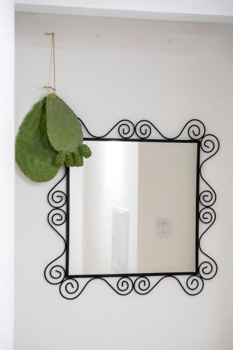 a mirror hanging on a wall with a green plant at Desideri di Puglia in Barletta