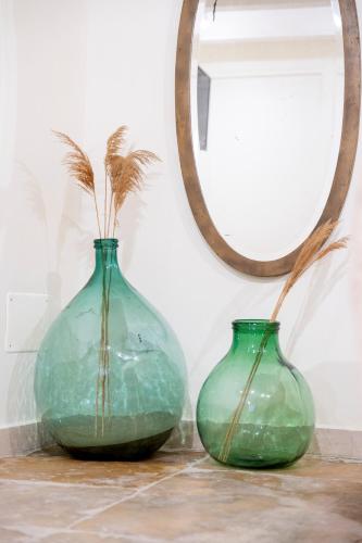 two green vases sitting on a table with a mirror at Desideri di Puglia in Barletta