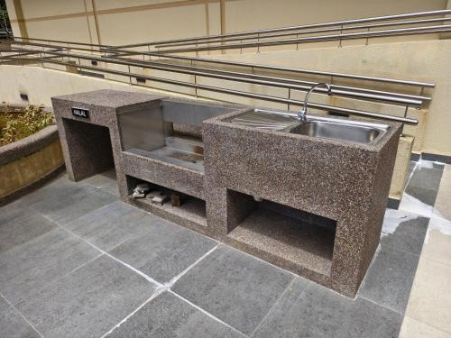 a stone counter with a sink in a building at Riverine Diamond 7 RDB Studio CK - Free 1 Parking, Netflix & Cozy Retreat Couples, Families in Kuching