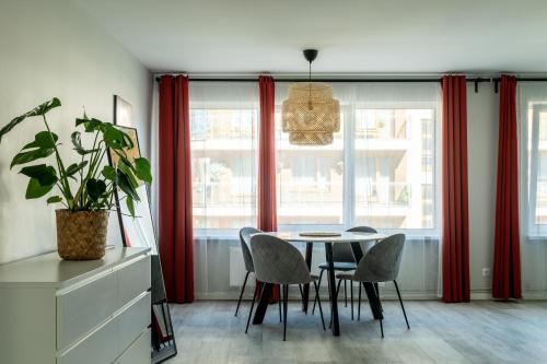 a dining room with red curtains and a table and chairs at Sigulda Center with Balcony and Self check-in in Sigulda