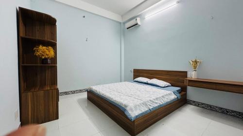 a bedroom with a bed and a shelf with flowers at Beachside Home, Ngũ Hành Sơn, Đà Nẵng in Da Nang