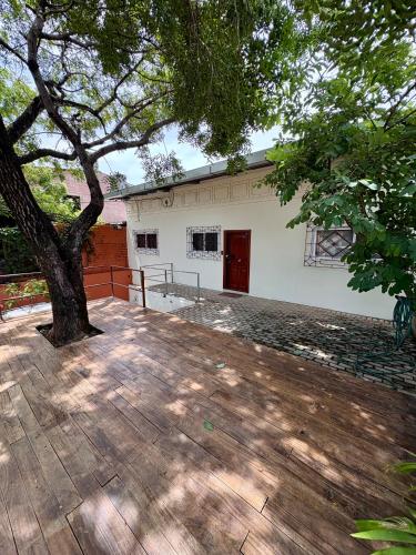 a building with a tree and a wooden deck at Casa en La Trinidad in La Unión