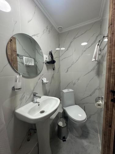 a bathroom with a sink and a toilet and a mirror at Belon Garden Hotel in Prigorodnyy