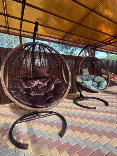 two wicker chairs sitting under a roof at Belon Garden Hotel in Prigorodnyy