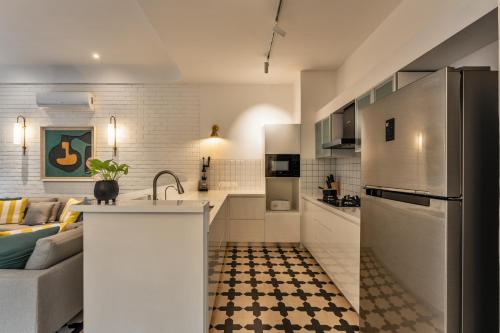 a kitchen and a living room with a refrigerator at La Masillia, 2 BHK with Private Pool, 15 mins from Morjim Beach, Wifi, Peaceful location, Kitchen, Security, Patio in Siolim