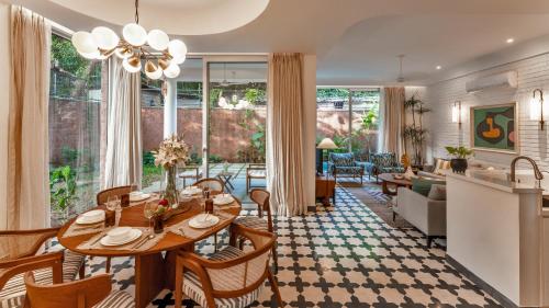 a dining room and living room with a table and chairs at La Masillia, 2 BHK with Private Pool, 15 mins from Morjim Beach, Wifi, Peaceful location, Kitchen, Security, Patio in Siolim