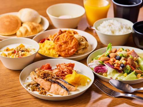 a wooden table with plates of food on it at Chisun Hotel Kamata in Tokyo