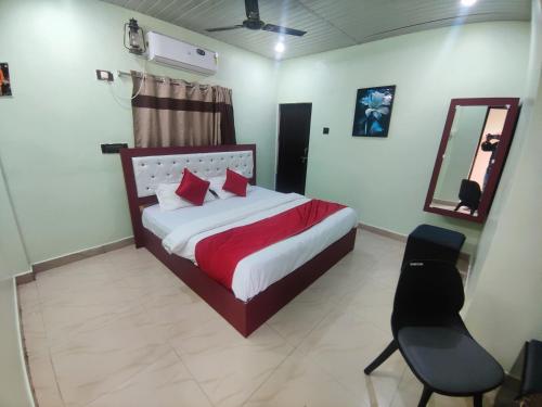 a bedroom with a bed and a chair and a mirror at Hotelchocolateinn in Visakhapatnam