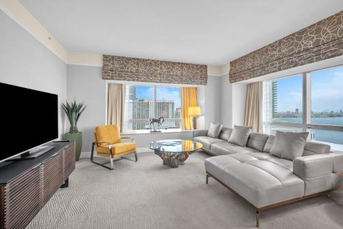 a living room with a couch and a tv at 2 Bedroom OR King Studio Suites Four Seasons Hotel Miami Free Wi-Fi & Free Parking in Miami