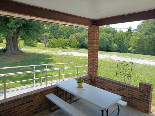 a picnic table on a porch with a view of a field at Lakeland Way in Jefferson City