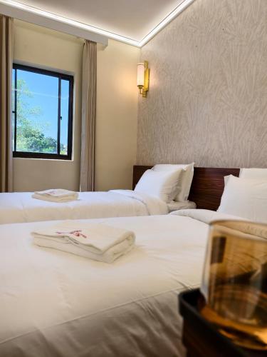 a hotel room with two beds with white sheets at Guan Gong Hotel Jin Shang Development Jonker Street in Malacca