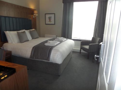 a hotel room with a bed and a chair and a window at The Croft Hotel in Darlington