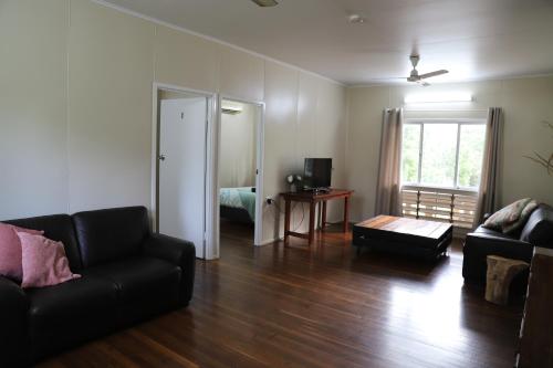 a living room with a black couch and a bed at Mt Bundy Station in Adelaide River