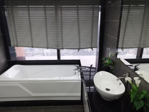a bathroom with a white tub and a sink at My Residence Villa Times Square KL in Kuala Lumpur