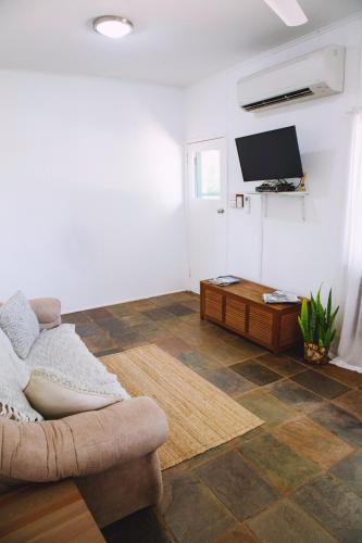 a living room with a couch and a flat screen tv at Mt Bundy Station in Adelaide River
