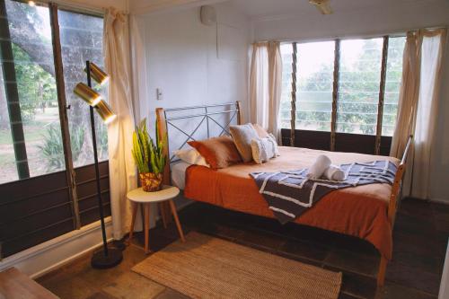 a bedroom with a bed and a lamp and windows at Mt Bundy Station in Adelaide River