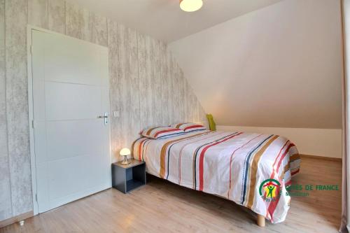 een kleine slaapkamer met een bed en een kast bij La vigerie in Carnac