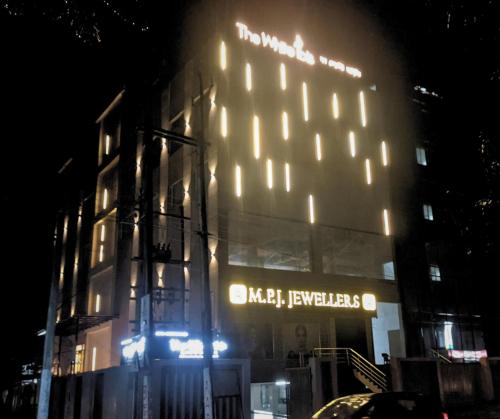 a building with lights on the side of it at night at THE WHITE IBIS A Unit of S S Manor in Sivasagar