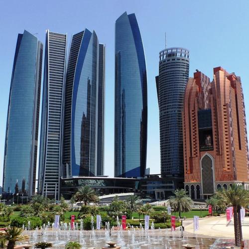 a group of tall buildings in a city with a fountain at Abu Dhabi City Tour in Sabkhah
