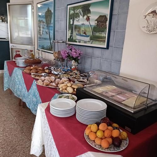 a buffet line with plates of food on tables at Hotel La Terrazza in Porto San Giorgio