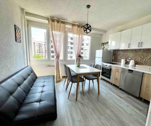 salon z kanapą i stołem w kuchni w obiekcie Apartment studio 30 w Sarajewie
