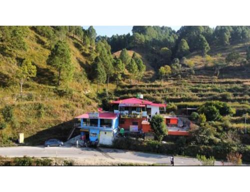 a house on top of a hill next to a parking lot at Sumangalam Homestay सुमंगलम होमस्टे in Devaprayāg