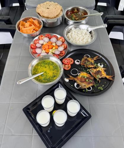 a table with many different types of food on it at Mishita Resort couple friendly with pool near beach in Alibaug