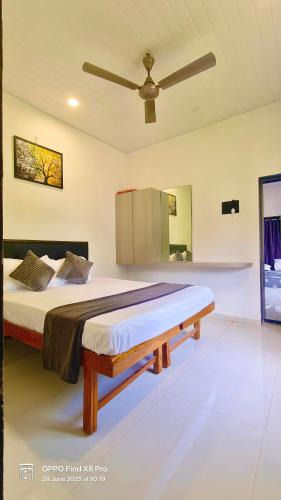 a large bed in a room with a ceiling fan at Mishita Resort couple friendly with pool near beach in Alibaug