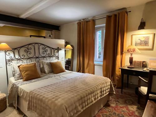 a bedroom with a bed and a desk and a computer at Le Clos de Mara in Issus