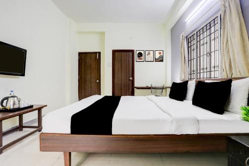 a bedroom with a large bed and a television at Super Collection O Begumpet Formerly Alpine Glow Sunrise in Hyderabad