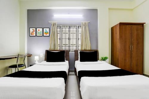 a room with three beds and a window at Super Collection O Begumpet Formerly Alpine Glow Sunrise in Hyderabad